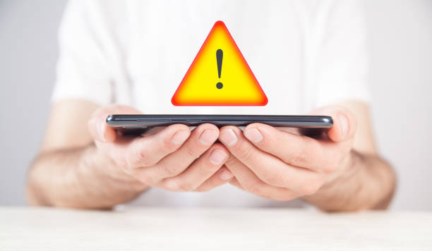 Man showing smartphone with a Warning symbol.