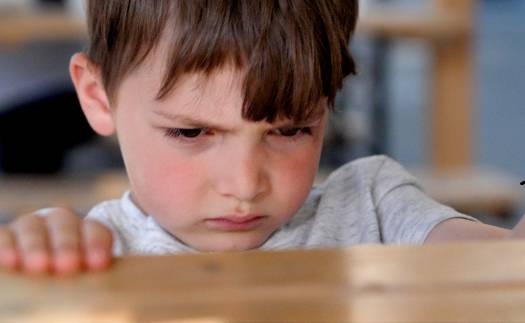 Very upset caucasian little boy looking away